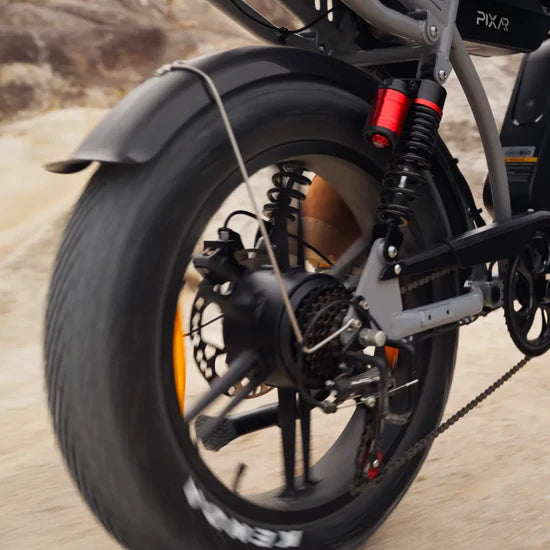 Close-up of a motorcycle wheel with suspension and chain on a blurred natural background
